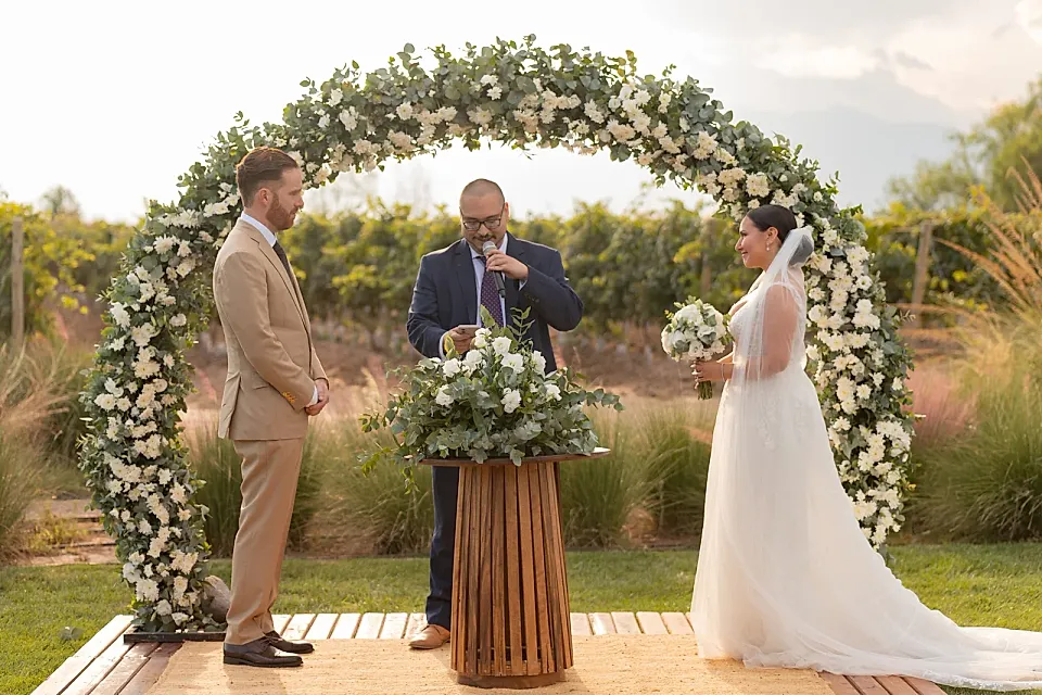 Ceremonia de casamiento bajo un arco floral en un viñedo de Mendoza