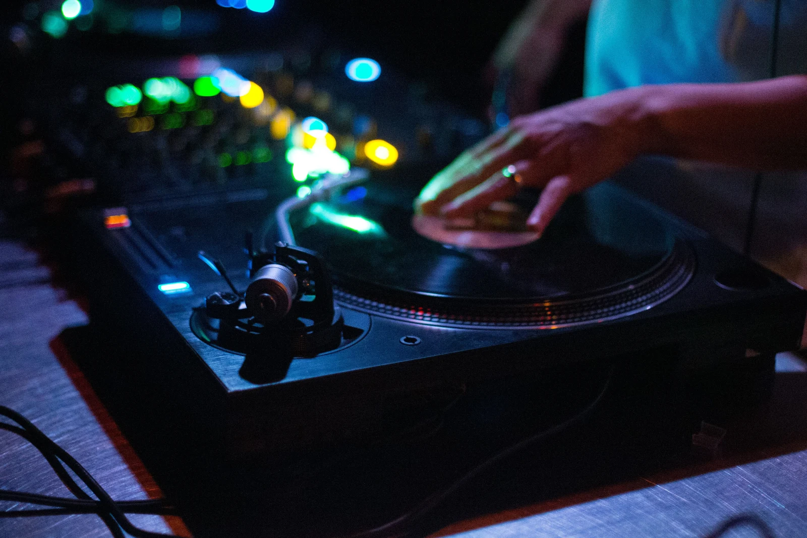 Mano de un DJ sobre una bandeja durante una fiesta