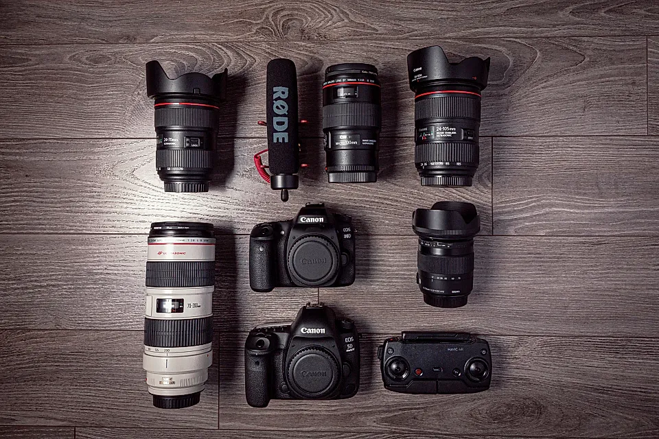 Dos cámaras y varios objetivos de fotografía organizados sobre una superficie de madera