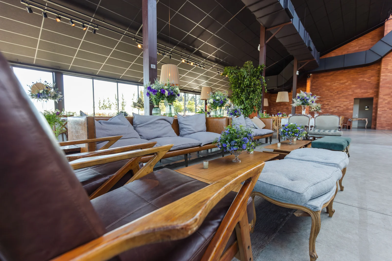 Living con sillones y flores dentro de un salón preparado para una recepción