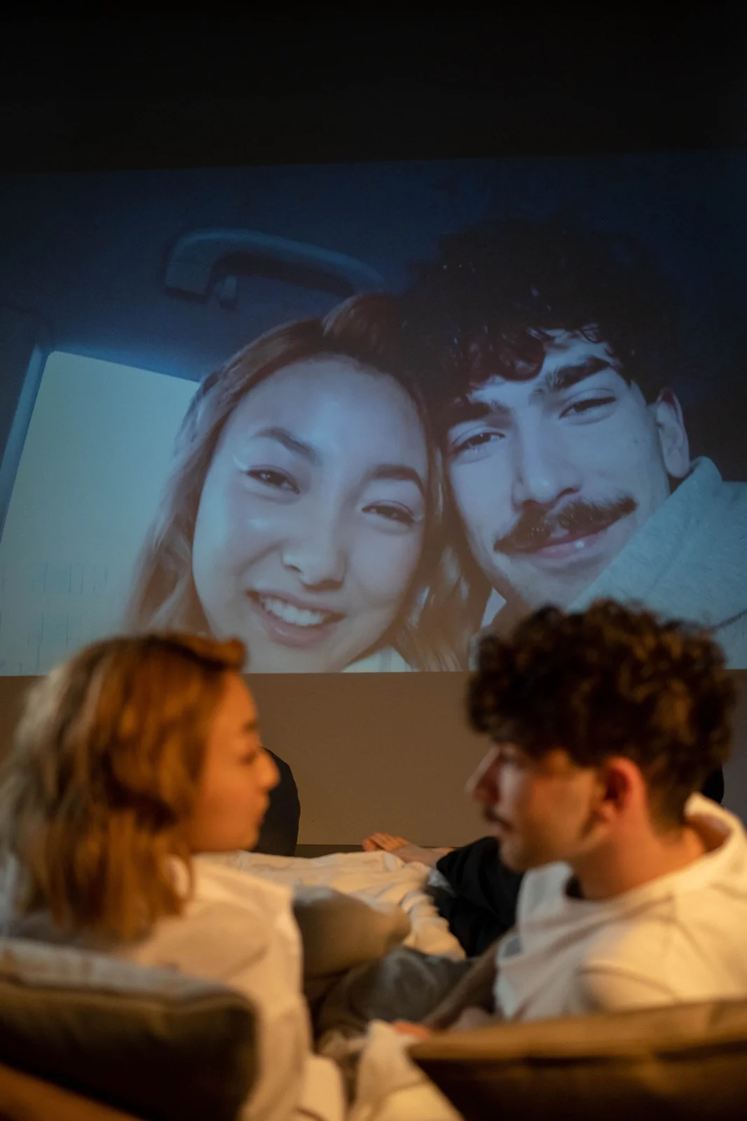 Dos personas sentadas ante una imagen proyectada en una pared