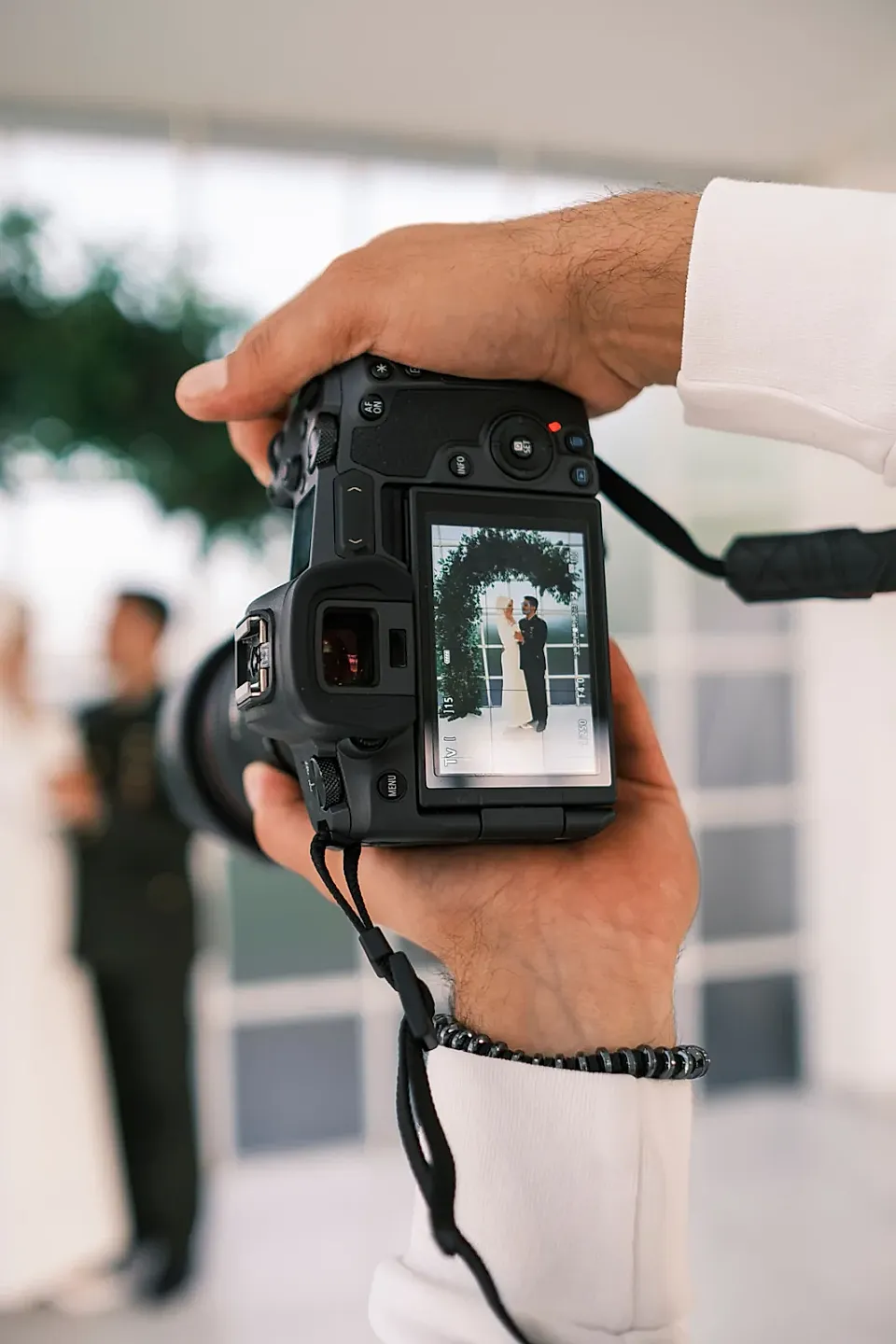 Fotógrafo encuadra a una pareja de casamiento en la pantalla de su cámara