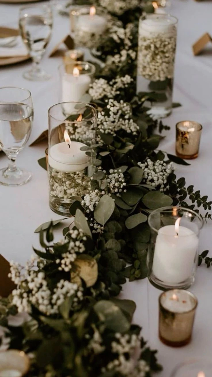 Centro de mesa con velas y flores blancas