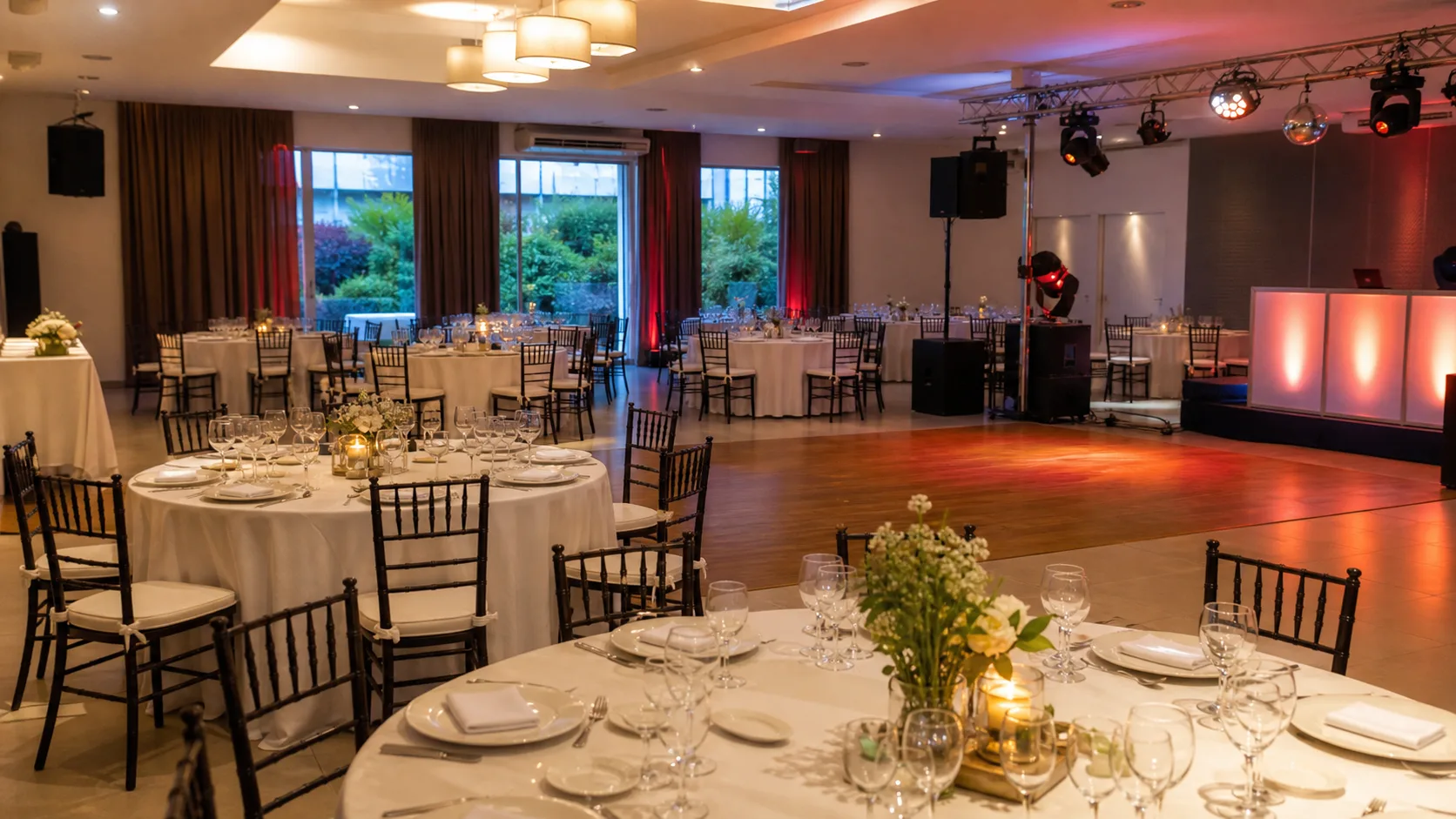 Salón de eventos con mesas y pista preparado para invitados