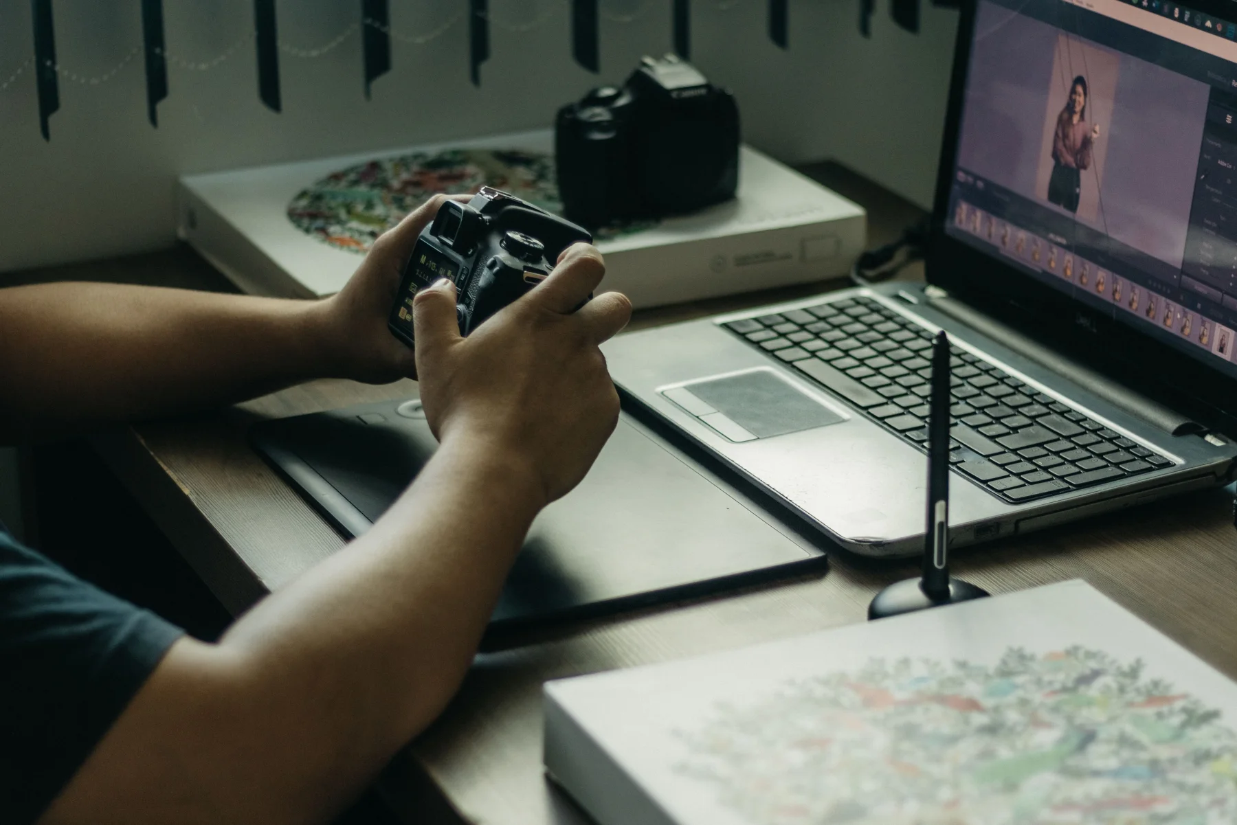 Fotógrafo trabajando con una cámara frente a una computadora durante la edición