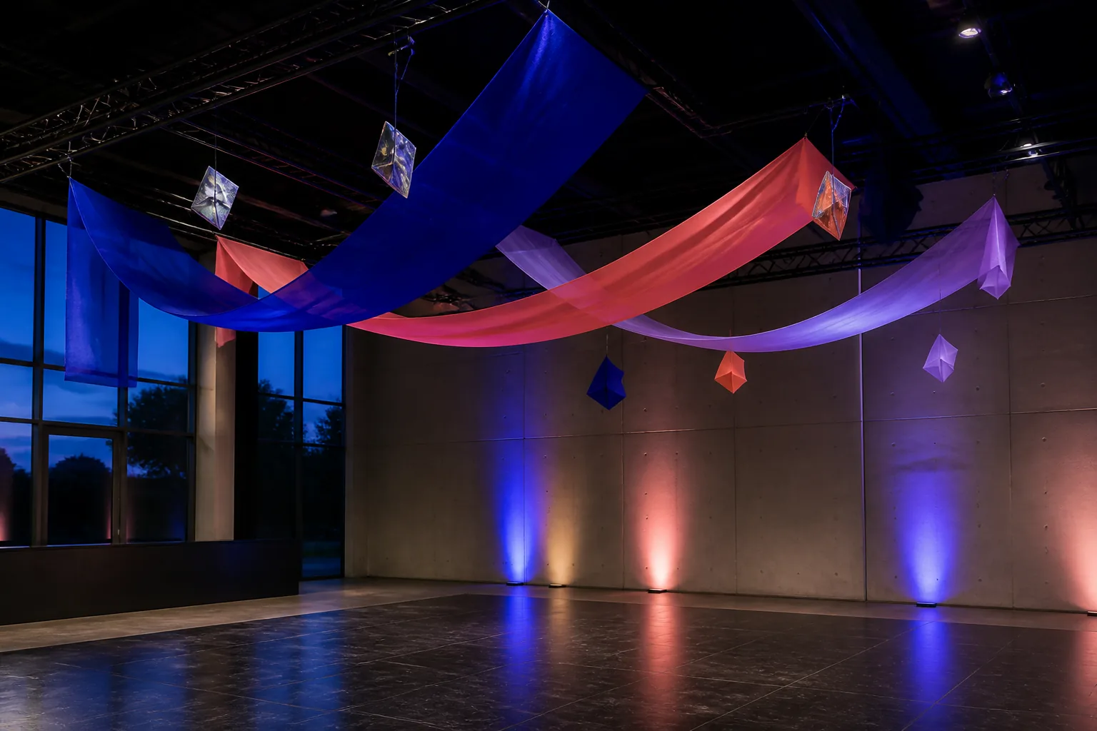 Pista de fiesta de 15 con cintas azules, coral y lilas suspendidas bajo luces de color