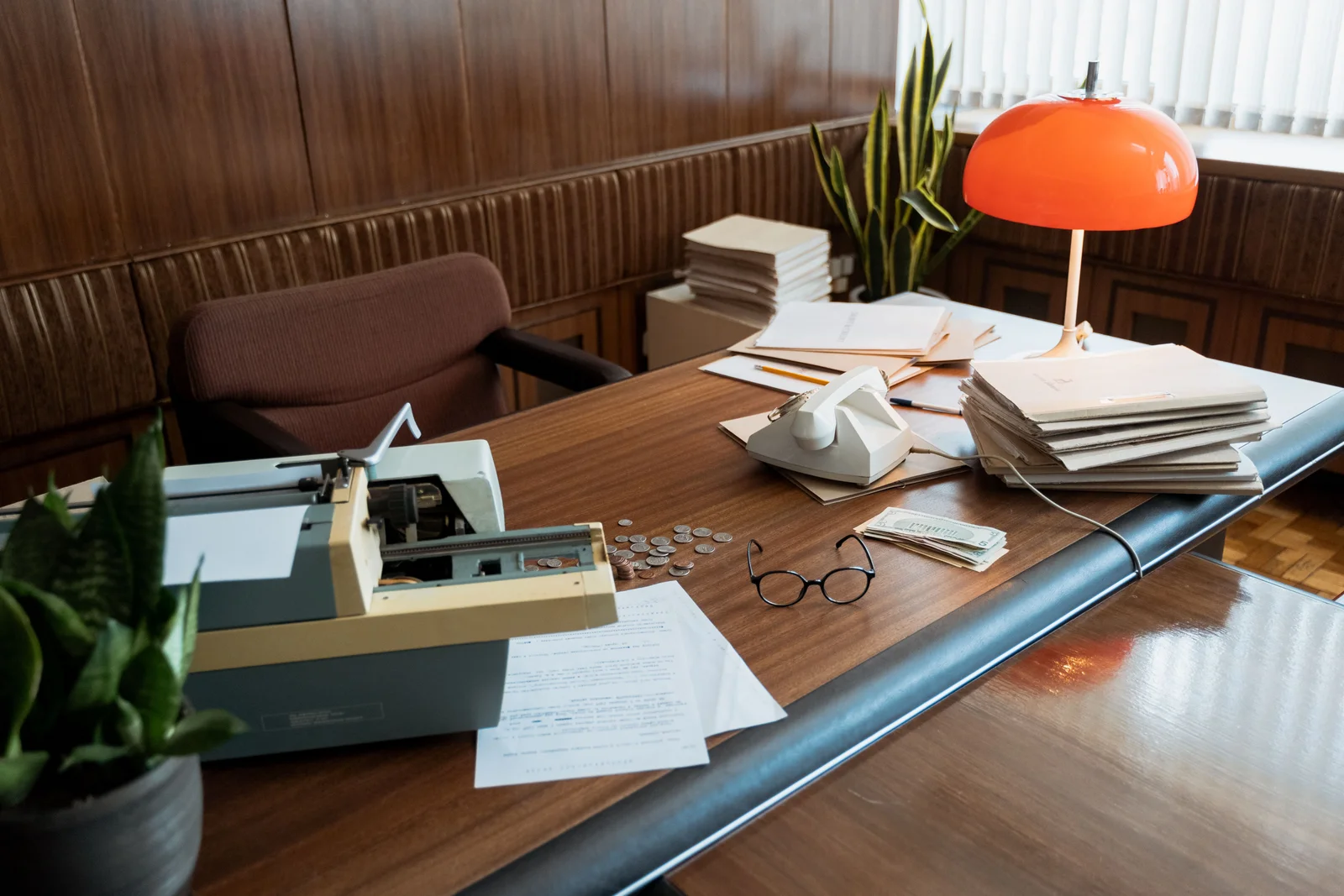 Escritorio retro con máquina de escribir, teléfono, carpetas y anteojos