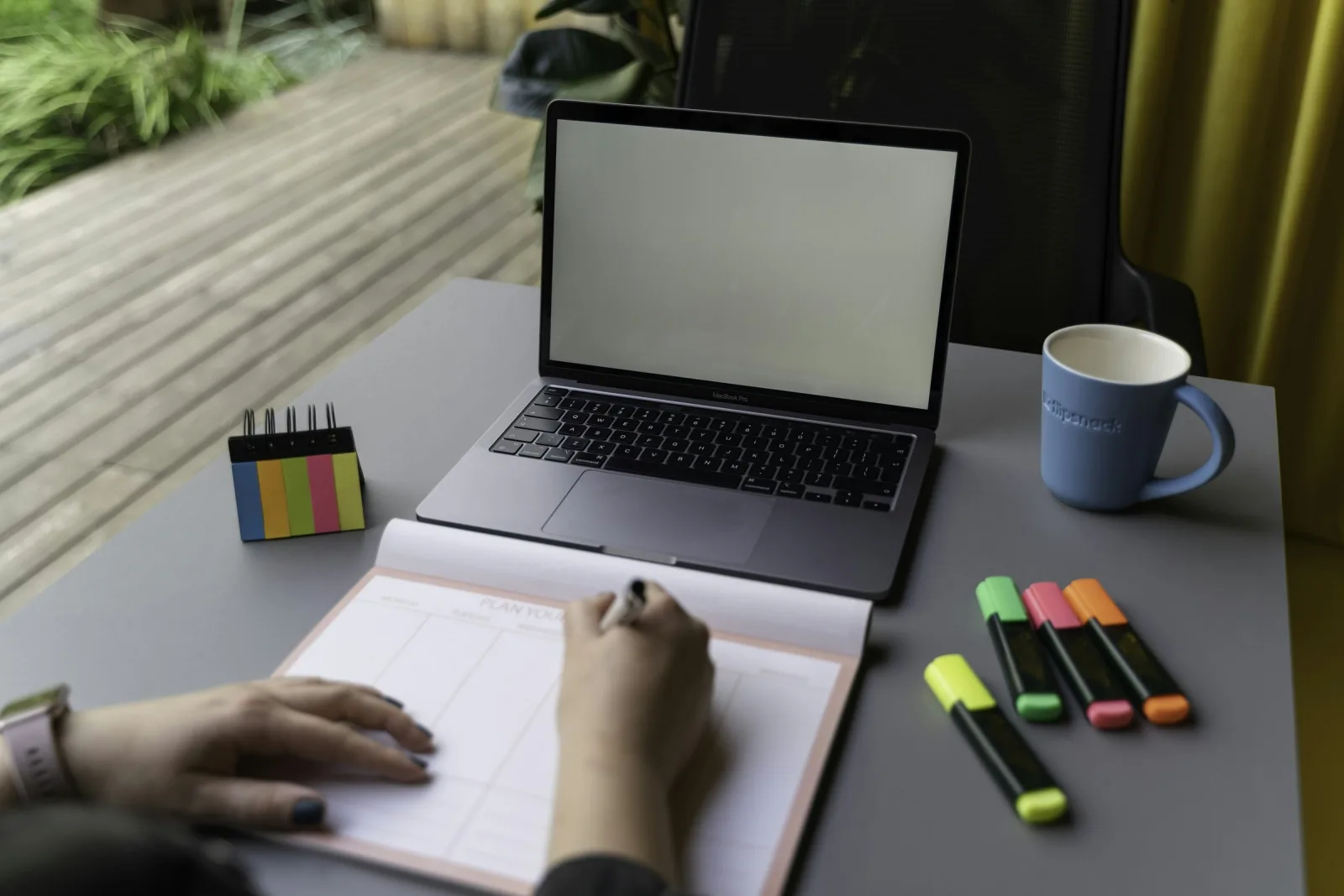 Persona organizando fechas y tareas para un evento frente a una notebook