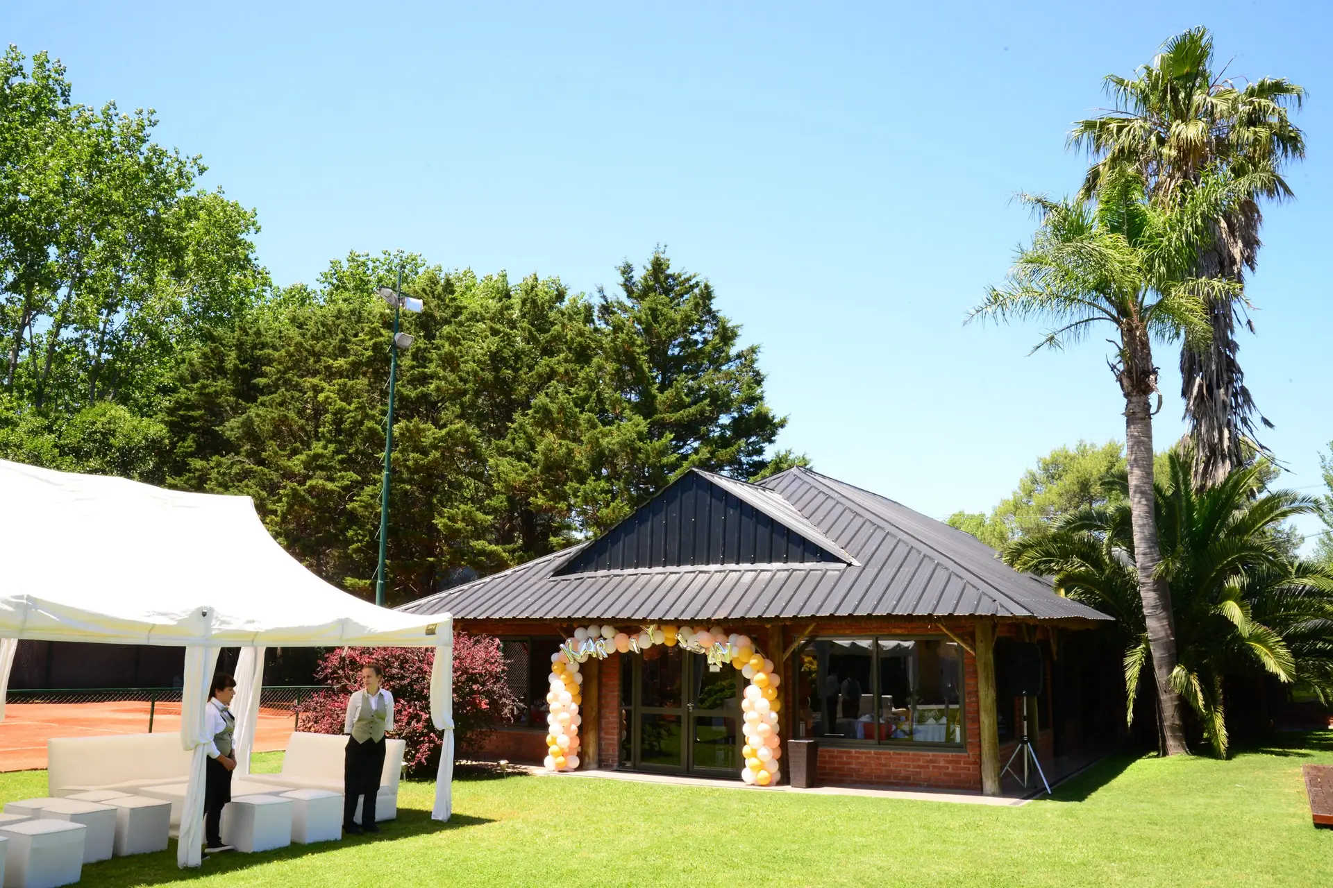 Salón de ladrillo rodeado por el parque de Quinta El Reencuentro en Ezeiza
